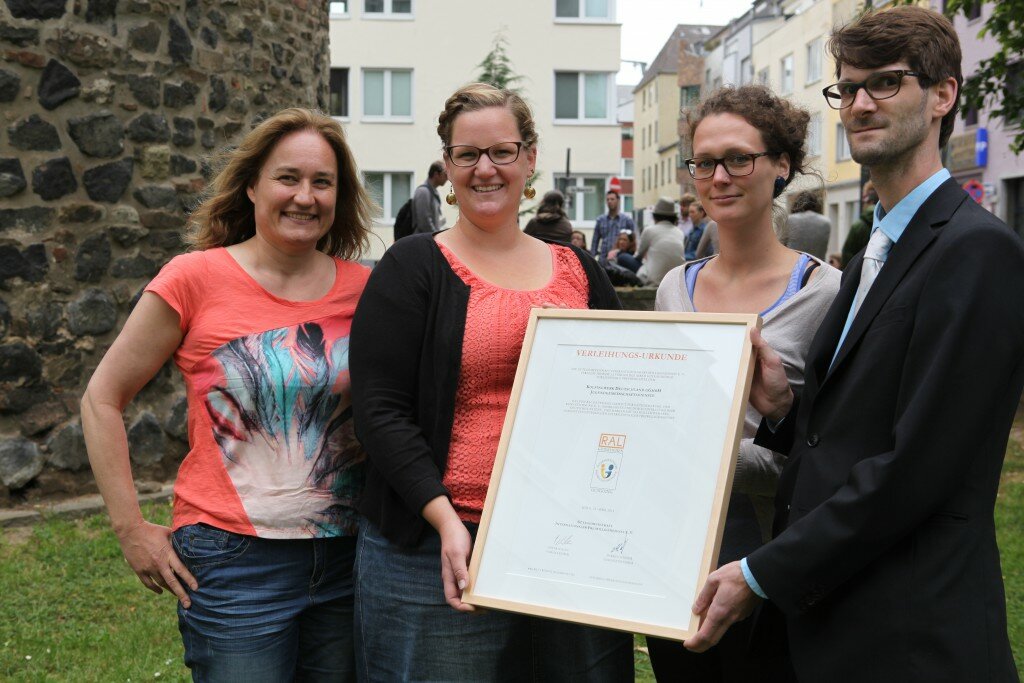 Abteilungsleiterin Annette Fuchs, Samantha Ruppel und Linda Waldhof von den Kolping Jugendgemeinschaftsdiensten (v.l.) nehmen vom Geschäftsführer der Gütegemeinschaft Markus Linsler die Verleihungs-Urkunde entgegen. Foto: Kolpingwerk Deutschland.